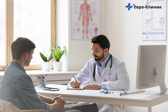 Мужчина сидит на приему у врача